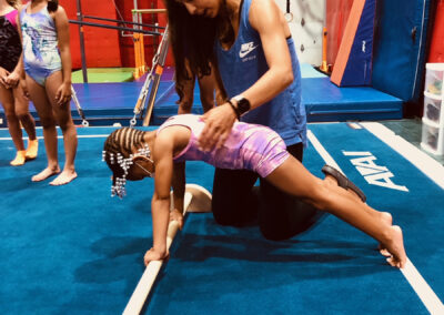 Coach helping young girl gymnast